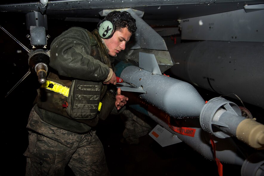 U.S. Air Force Senior Airman Mateo Palacios, a weapons load crew member with the 35th Aircraft Maintenance Squadron, affixes a guidance fin onto an armament during exercise Beverly Sunrise 16-03 at Misawa Air Base, Japan, March 22, 2016. Despite inclement weather, Palacios and his team members worked quickly and efficiently to arm several weapons systems onto awaiting F-16 Fighting Falcons, allowing the aircraft to fly again in an expeditious manner. (U.S. Air Force photo by Senior Airman Patrick S. Ciccarone) 