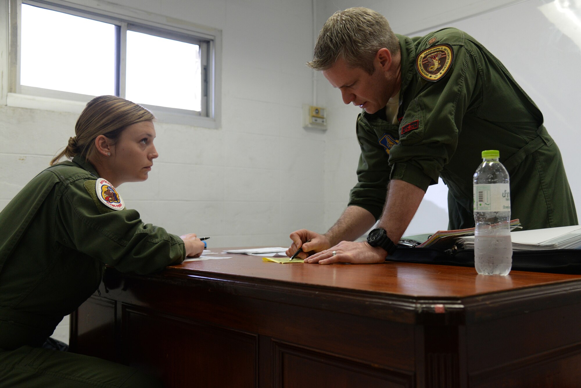 U.S. Air Force 1st Lt. Brittany Trimble, 36th Fighter Squadron pilot, receives a mission briefing from her flight lead Maj. Shawn Walsh, 36th FS director of staff, Feb. 15, 2016, at Korat Royal Thai Air Force Base, Thailand. Coming straight from B Course, Trimble has only been flying actively with the 36th FS since October 2015 and is one of the newest wingmen in the squadron. (U.S. Air Force photo by Staff Sgt. Amber E. Jacobs)