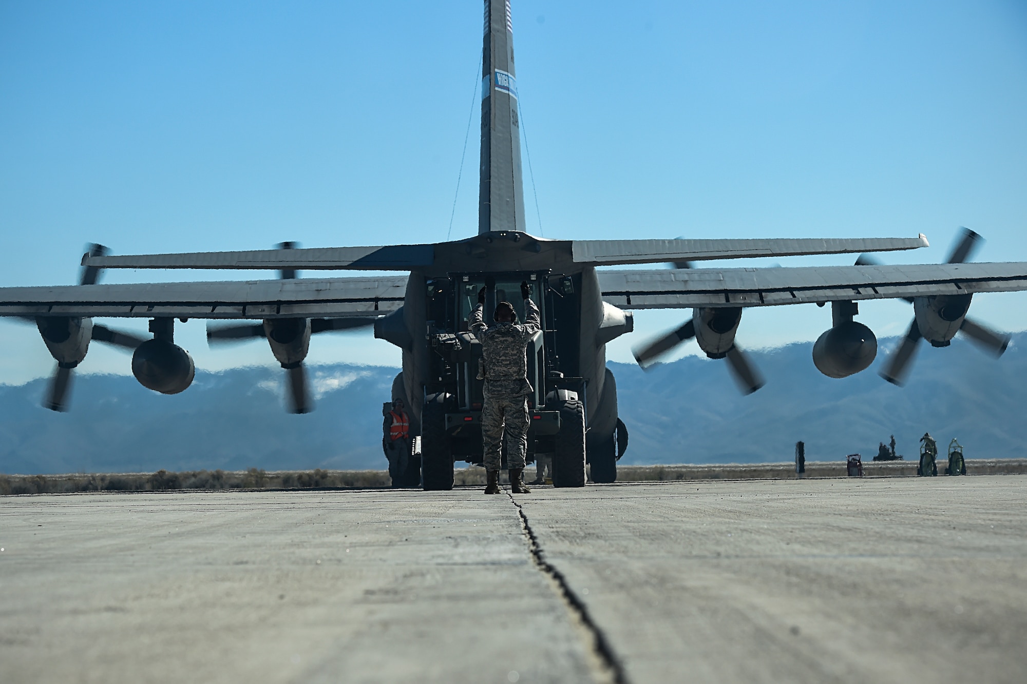 Senior Airman Tyler Connell, 821st Contingency Response Squadron Aerial Port Flight, guides a 10K all-terrain vehicle away from a C-130 Hercules, after performing an engine running offload during Exercise Turbo Distribution 16-02, March 16, 2016, at Amedee Army Airfield, Calif.  During an engine running offload aerial porters offload the cargo while the engines are still on so the aircraft can quickly takeoff.  (U.S. Air Force photo by Staff Sgt. Robert Hicks/Released)