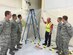 A fire protection engineer trains fire alarm shop staff at Nellis Air Force Base, Nevada, on a newly installed flame detection system during acceptance testing of a hangar addition. (Air Force photo/Susan Lawson/Released)



