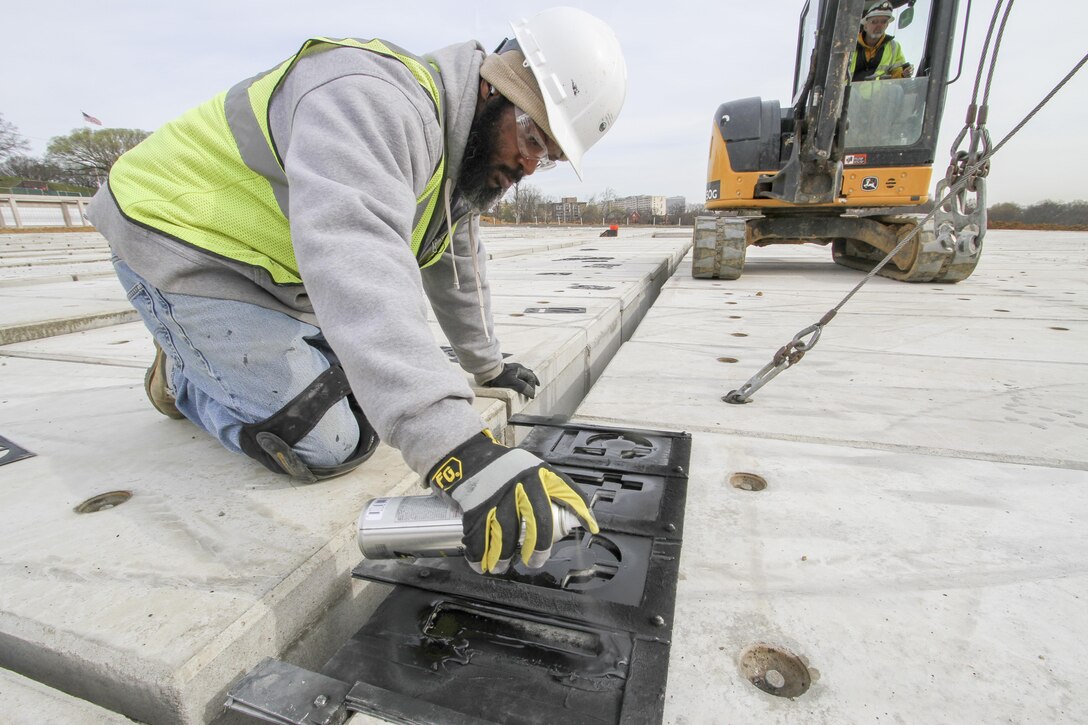 ARLINGTON, Va. – Darian Moon, a contractor working on the Arlington National Cemetery’s Millennium Project paints identification numbers on the top off a pre-cast, pre-placed double-depth-concrete liner, March 22, 2016. The liners are a first for the cemetery and will maximize burial opportunities within the 27 acre expansion project. (U.S. Army photo/Patrick Bloodgood)