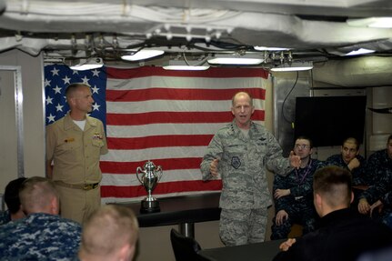 U.S. Air Force Lt. Gen. Stephen W. Wilson, U.S. Strategic Command (USSTRATCOM) deputy commander (standing right), provides remarks after an award ceremony honoring the USS Wyoming (SSBN 742) at Naval Submarine Base Kings Bay, Ga., March 23, 2016. During the ceremony, Wilson and Mr. Tom Janssen, Strategic Command Consultation (SCC) Committee representative (not pictured), presented the 2015 Omaha Trophy, ballistic missile submarine category, to U.S. Navy Cmdr. Kenneth M. Curtin Jr., commanding officer of USS Wyoming Gold Crew (standing left), and U.S. Navy Cmdr. Wayne C. Wall, commanding officer of USS Wyoming Blue Crew (not pictured), in recognition of the USS Wyomingâ€™s contributions to USSTRATCOM's global strategic missions. The Omaha Trophy, which dates back to the U.S. Air Force's Strategic Air Command, was originally created by the SCC in 1971. At the time, a single trophy was presented annually as a token of appreciation to USSTRATCOM's best wing. Since then, the tradition has evolved to unit-level awards that recognize the command's premier intercontinental ballistic missile (ICBM) wing, ballistic missile submarine, strategic bomber wing and global operations (space/cyberspace) unit. This year, a new category was added to include the combatant command's top strategic aircraft wing. (U.S. Navy photo courtesy of Commander, Submarine Group Ten\r\nPublic Affairs) Story Available: https://www.stratcom.mil/news/2016/595/-/