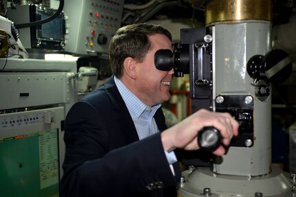 Mr. Tom Janssen, Strategic Command Consultation (SCC) Committee representative, looks through the periscope of the USS Wyoming (SSBN 742) at Naval Submarine Base Kings Bay, Ga., March 23, 2016. While there, U.S. Air Force Lt. Gen. Stephen W. Wilson, U.S. Strategic Command (USSTRATCOM) deputy commander (not pictured), and Janssen presented the 2015 Omaha Trophy, ballistic missile submarine category, to U.S. Navy Cmdr. Kenneth M. Curtin Jr., commanding officer of USS Wyoming Gold Crew (not pictured), and U.S. Navy Cmdr. Wayne C. Wall, commanding officer of USS Wyoming Blue Crew (not pictured), during a ceremony in recognition of the USS Wyomingâ€™s contributions to USSTRATCOM's global strategic missions. The Omaha Trophy, which dates back to the U.S. Air Force's Strategic Air Command, was originally created by the SCC in 1971. At the time, a single trophy was presented annually as a token of appreciation to USSTRATCOM's best wing. Since then, the tradition has evolved to unit-level awards that recognize the command's premier intercontinental ballistic missile (ICBM) wing, ballistic missile submarine, strategic bomber wing and global operations (space/cyberspace) unit. This year, a new category was added to include the combatant command's top strategic aircraft wing. (U.S. Navy photo courtesy of Commander, Submarine Group Ten Public Affairs) Story Available: https://www.stratcom.mil/news/2016/595/-/