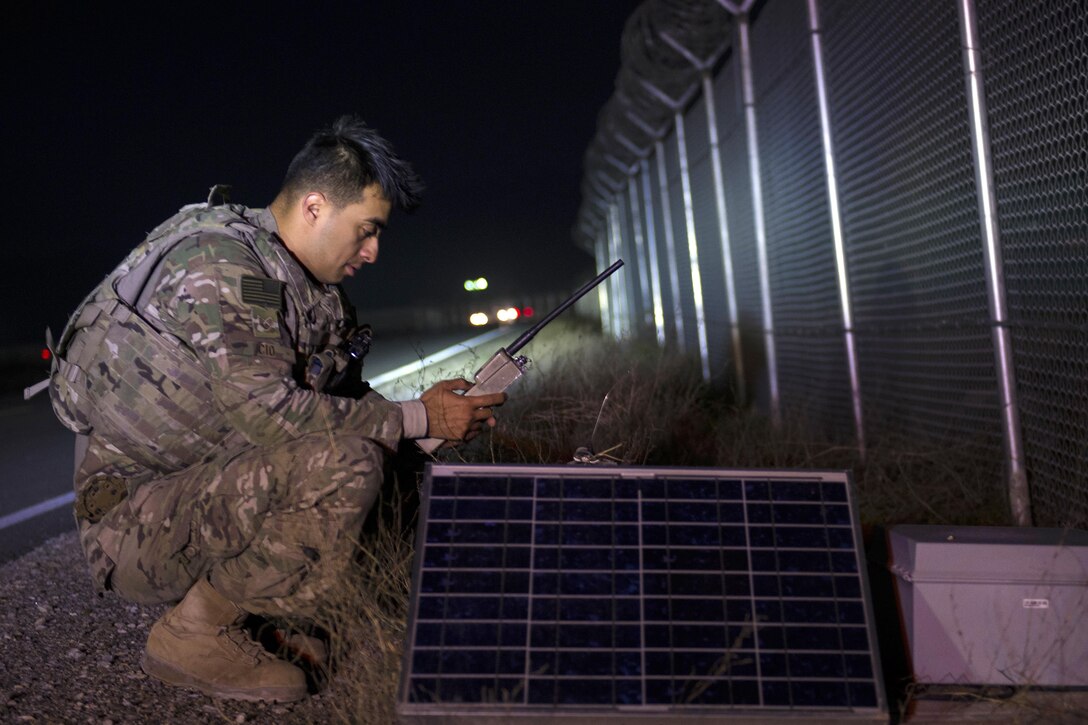 Air Force Staff Sgt. Rodrigo Cid resets a sensor along a fence line during a walking patrol at Bagram Airfield, Afghanistan, March 23, 2016. Cid is assigned to the 455th Expeditionary Security Forces Squadron Flightline Security Quick Reaction Force team. Air Force photo by Tech. Sgt. Robert Cloys