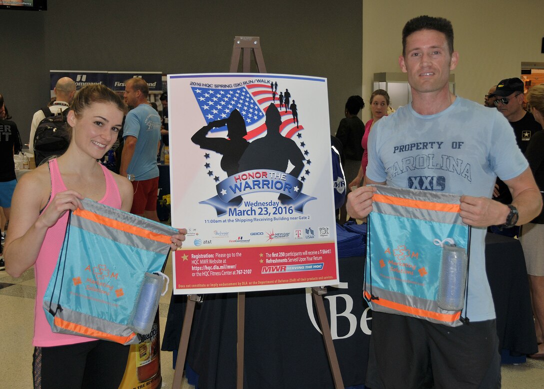 Erin Hunt with Defense Logistics Agency Strategic Materials and Air Force Capt. Brandon Bryan from the Air Force Petroleum Agency show off prizes they won as the first place female and male runners in the Spring Fling 5K at Fort Belvoir, Virginia, March 20.