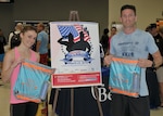 Erin Hunt with Defense Logistics Agency Strategic Materials and Air Force Capt. Brandon Bryan from the Air Force Petroleum Agency show off prizes they won as the first place female and male runners in the Spring Fling 5K at Fort Belvoir, Virginia, March 20.