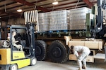 Louisiana National Guard members from the 1086th Transportation Company load and stack bottles of water to be delivered and distributed to affected parishes during emergency flood operations in Bunkie, Louisiana, March 13, 2016. The LANG has been assisting local officials in the flood fight since March 9. 