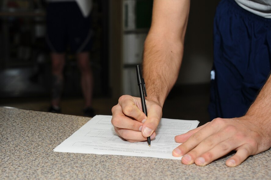 U.S. Air Force Senior Airman Phillip West, 355th Security Forces Squadron defender, fills out a 36-2905 Fitness Screening Questionnaire before a fitness assessment at Davis-Monthan Air Force Base, Ariz., Feb. 24, 2016. . The D-M fitness assessment cell, which administers the fitness assessments, is in the process of transitioning all physical paperwork to digital copies to save time and resources.  (U.S. Air Force photo by Airman 1st Class Mya M. Crosby/Released)