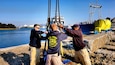 Soldiers from the 511th Engineer Dive Detachment prepare to remove slings from a concrete pier being removed from the water. The active duty unit removed a dozen 10,000 pound pilings at the reserve center as part of a Troop Construction project, saving the Army money while performing real world training.
