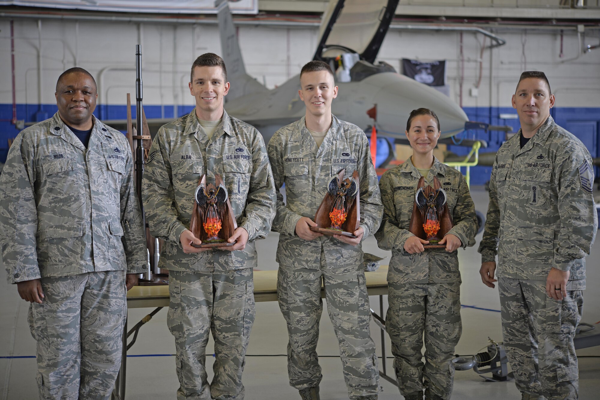 Load crew four from the 33rd Fighter Wing accept trophies after winning the base wide load competition at Eglin Air Force Base, Fla., March 18, 2016. Three load teams participated in the first base wide load competition between the 33rd FW and the 96th Test Wing involving the F-35A Lightning II. During this competition the F-35, F-15 Eagle and F-16 Fighting Falcon were used to test teams on their skills at loading munition onto an aircraft. (U.S. Air Force photo/Staff Sgt. Tarelle Walker)