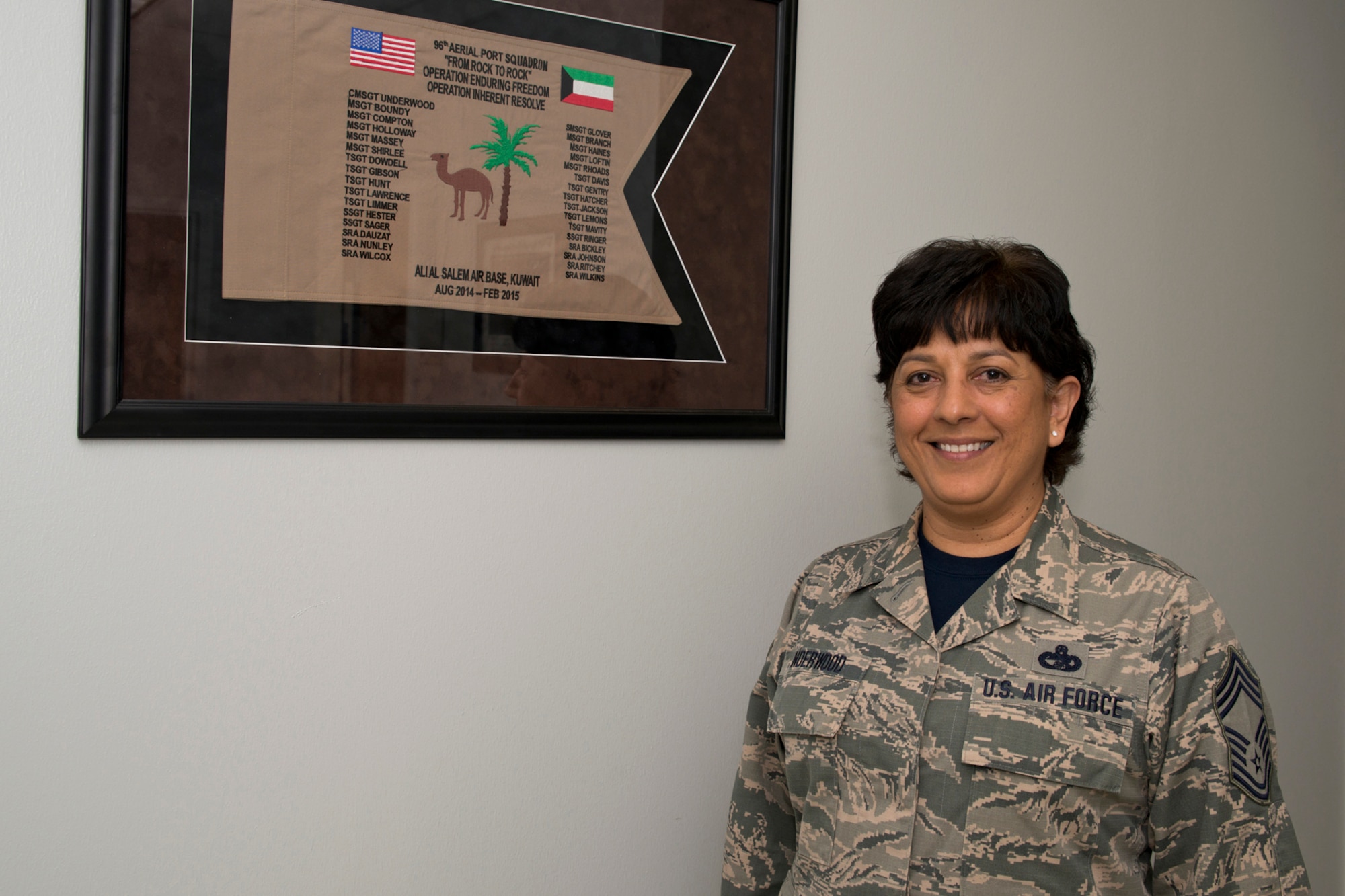 U.S. Air Force Reserve Chief Master Sgt. Cynthia Underwood, the air transportation superintendent for the 96th Aerial Port Squadron, poses for a photo at Little Rock Air Force Base, Ark., Mar. 4, 2016. The memento flag details the date, time and place of her deployment, which she described as one of the highlights of her Air Force career. (U.S. Air Force photo by Master Sgt. Jeff Walston/Released)
