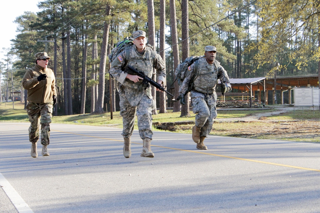 Sgt. Sydnee Coffman, 104th Training Division, cheers on Staff Sgt. Robert Miller, 98th Training Division (Initial Entry Training), and Spc. Phillip Small, 104th Training Division, to push their limits in the last few feet of their 12-mile road march at Fort Jackson, S.C. on March 22 during the combined Best Warrior and Drill Sergeant of the Year competitions for the 108th Training Command (IET). This year's Best Warrior competition will determine the top noncommissioned officer and junior enlisted Soldier who will represent the 108th Training Command (IET) in the Army Reserve Best Warrior competition later this year at Fort Bragg, N.C. This year's Drill Sergeant of the Year competition will determine the top two drill sergeants who will compete in the TRADOC Drill Sergeant of the Year competition later this year at Fort Jackson, S.C.(U.S. Army photo by Maj. Michelle Lunato/released)