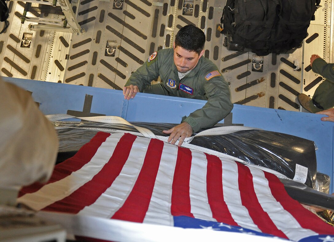 Tech. Sgt. Tripp Gilbert a reserve loadmaster from the 701st Airlift Squadron, adjusts cargo on a C-17 while in Havana, Cuba for a presidential support mission.  The diplomatic mission was the first time a sitting U.S. president has visited the communist nation in 88 years.  (U.S. Air Force photo by Maj. Wayne Capps)