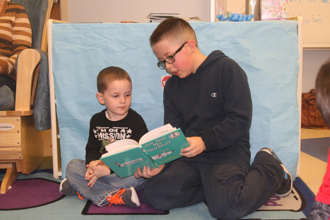 A fourth grader reads “Are You My Mother?” by P.D. James to a pre-K student.