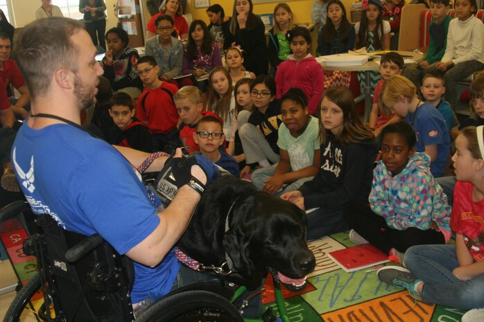 Air Force veteran Jesse Graham talks to third and fifth graders at Crossroads Elementary School aboard Marine Corps Base Quantico about his service dog, Stanley, a 2 1/2-year-old black lab Mar. 18.
