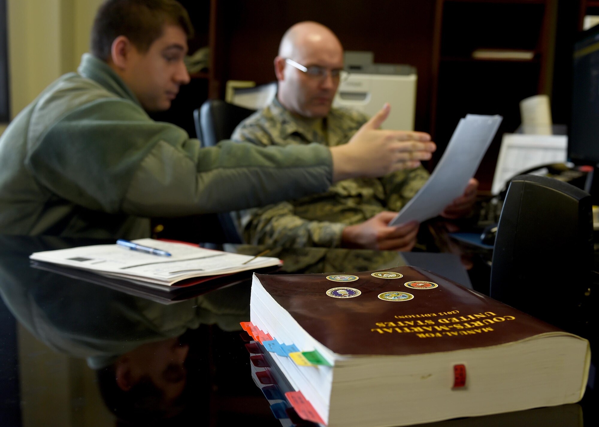 U.S. Air Force Airman 1st Class Alexander Bugerenko, 97th Air Mobility Wing Judge Advocate Office military justice paralegal, shows U.S. Air Force Col. Todd Hohn, 97th AMW commander how to properly process an Article 15, March 25, 2016 at Altus Air Force Base, Okla. As part of the 97th AMW Commander Working with Airmen Program, the wing commander visits different units to gain a hands on experience on how Airmen contribute the wing’s mission. (U.S. Air Force photo by Senior Airman Franklin R. Ramos/Released)