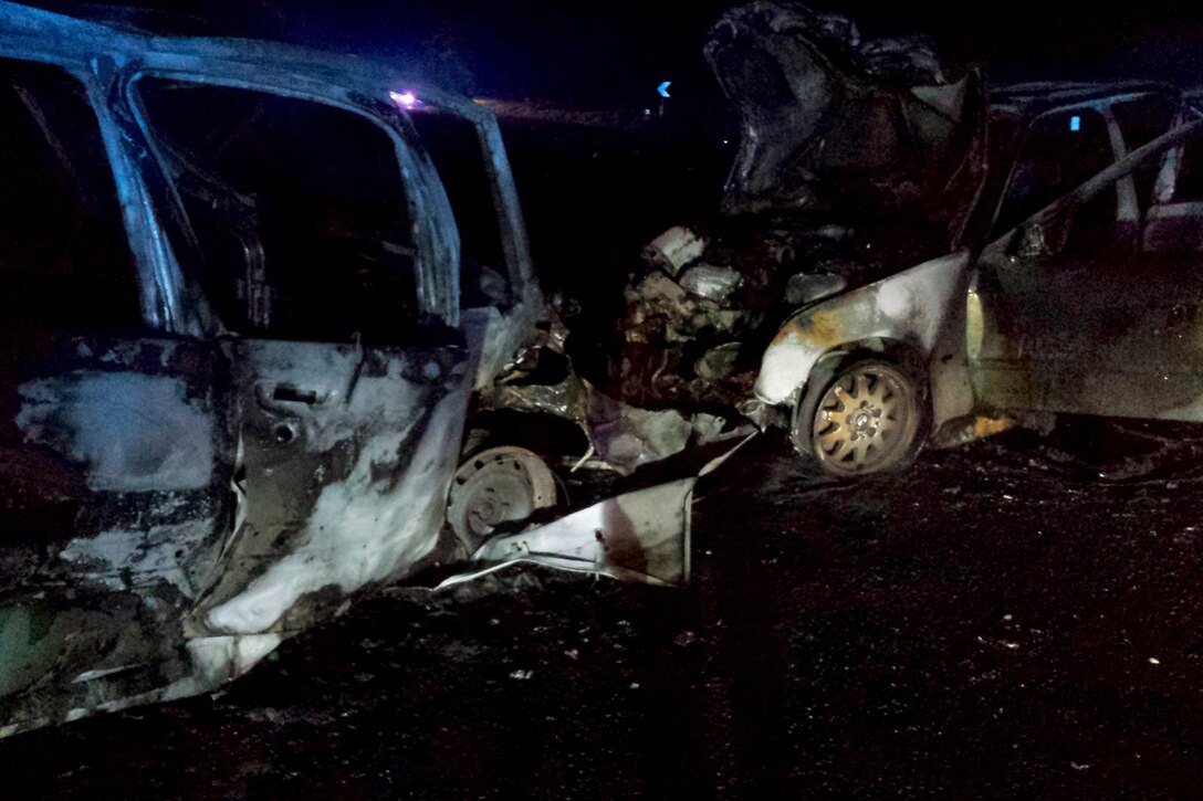 What is left of two cars after a potentially fatal accident sits on the side of the road May 12, 2014, near RAF Mildenhall, England. Staff Sgt. Vicente Gomez, 100th Aircraft Maintenance Squadron crew chief, performed life-saving assistance to the victims of the crash. Gomez was presented with the Airman’s Medal for his courageous acts. 