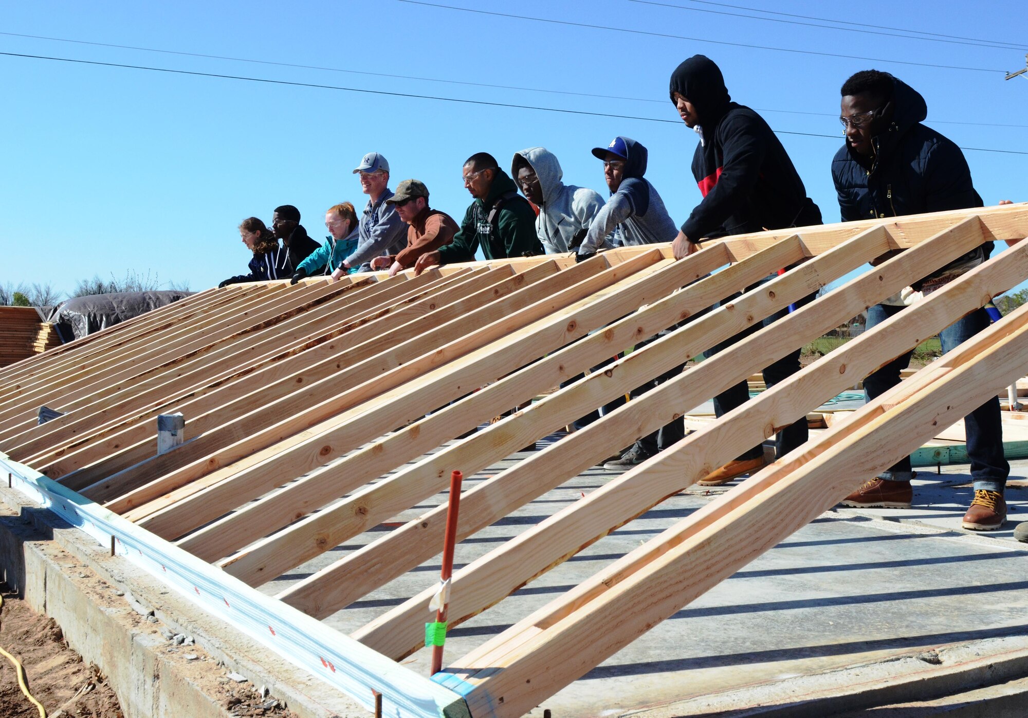 Cadets from the U.S. Air Force Academy lift the frame to a home in Oklahoma City March 22, 2016. The cadets traveled to Oklahoma City to spend their spring break teaming up with Habitat for Humanity to build a home for a lower-income family. (U.S. Air Force photo/Harry Lundy) 