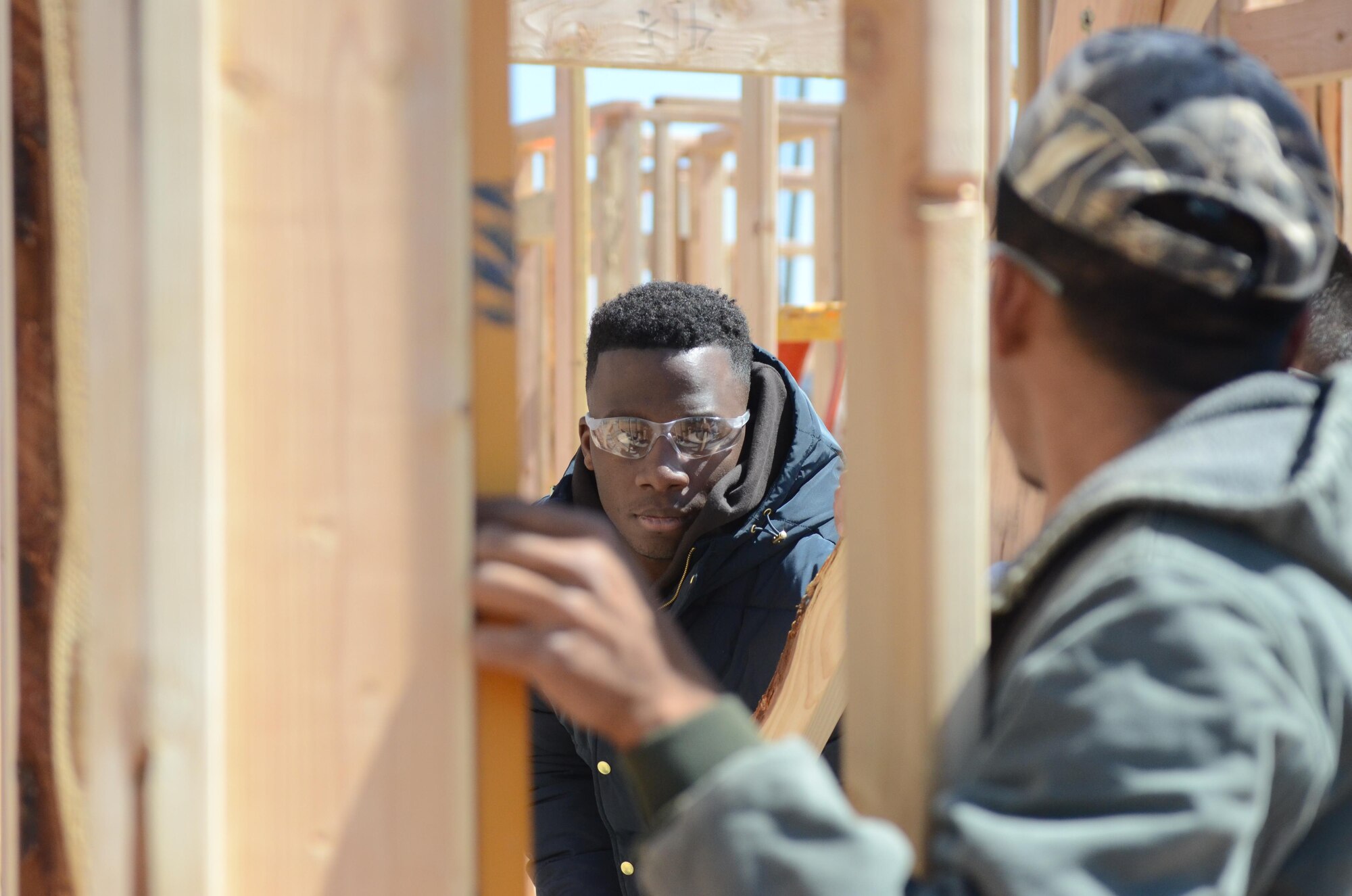 A cadet from the U.S. Air Force Academy stands inside the frame of a home he and other cadets and Habitat for Humanity volunteers are building for a lower-income family in Oklahoma City, Oklahoma, March 22, 2016. (U.S. Air Force photo/Harry Lundy) 