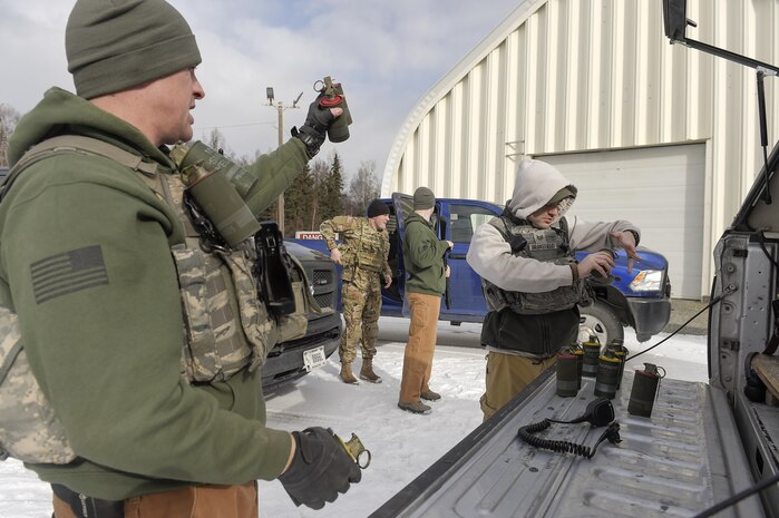 Airmen assigned to the 673rd Security Forces Squadron pack smoke grenades while preparing to conduct military working dog training at Joint Base Elmendorf-Richardson, Alaska, March 17, 2016. The Security Forces Airmen conducted the K-9 training with their Army counterparts, assigned to the 549th Military Working Dog Detachment, to keep their teams flexible to respond to law enforcement emergencies, and for overseas deployments. (U.S. Air Force photo/Alejandro Pena)