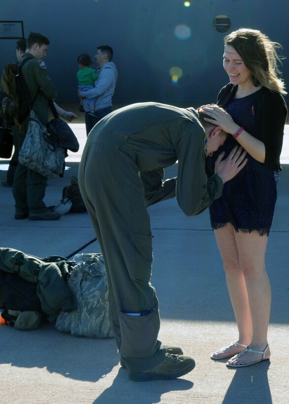 U.S. Air Force Senior Airman Dakota Brown, 40th Airlift Squadron crewchief, kisses his wife’s, Megan, stomach, March 21, 2016, at Dyess Air Force Base, Texas. Brown returned from a three month deployment, conducting a wide range of airland and airdrop missions with other Airmen from his squadron. (U.S. Air Force photo by Senior Airman Shannon Hall/Released)