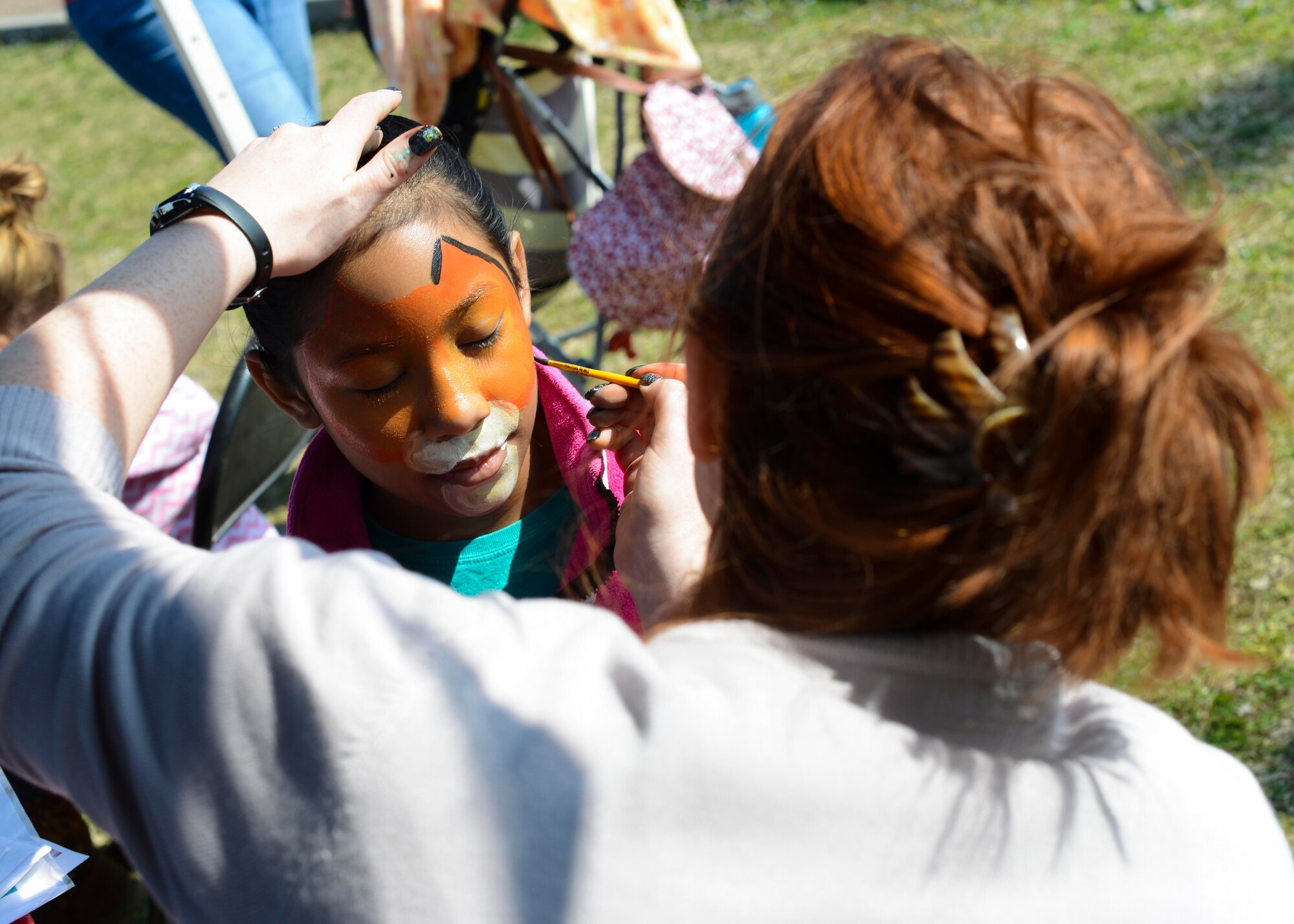 Mohogany Rembert gets her face painted during the Red Cross Carnival, March 19, 2016, at Aviano Air Base, Italy. In addition to emergency preparedness awareness, the event hosted games, a photo booth, and races for children and adults. (U.S. Air Force photo by Senior Airman Austin Harvill/Released)