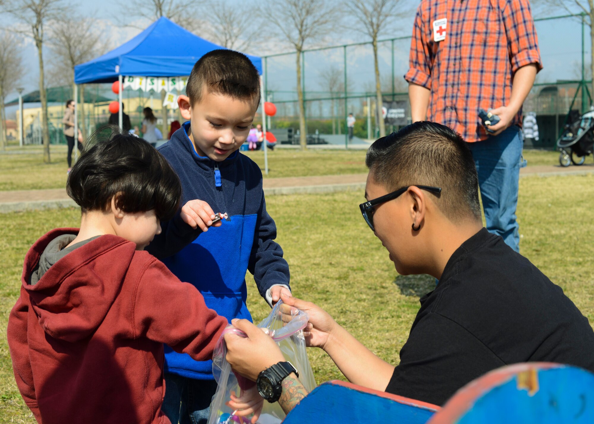 Jadyn and Ethan Wu get candy after winning a bag toss game during the Red Cross Carnival, March 19, 2016, at Aviano Air Base, Italy. The Aviano American Red Cross chapter hosted the event in recognition of American Red Cross Month. (U.S. Air Force photo by Senior Airman Austin Harvill/Released)