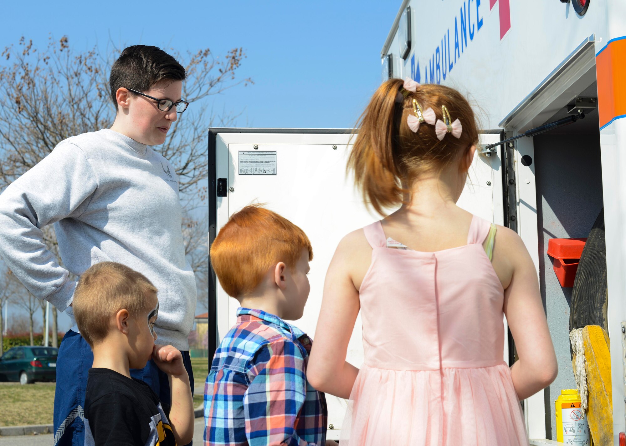 Airman 1st Class Kelly Pope, 31st Medical Operations Squadron emergency medical technician, talks to children about ambulatory equipment during the Red Cross Carnival, March 19, 2016, at Aviano Air Base, Italy. The carnival featured fire safety, disaster planning, and other emergency preparedness booths. (U.S. Air Force photo by Senior Airman Austin Harvill/Released)
