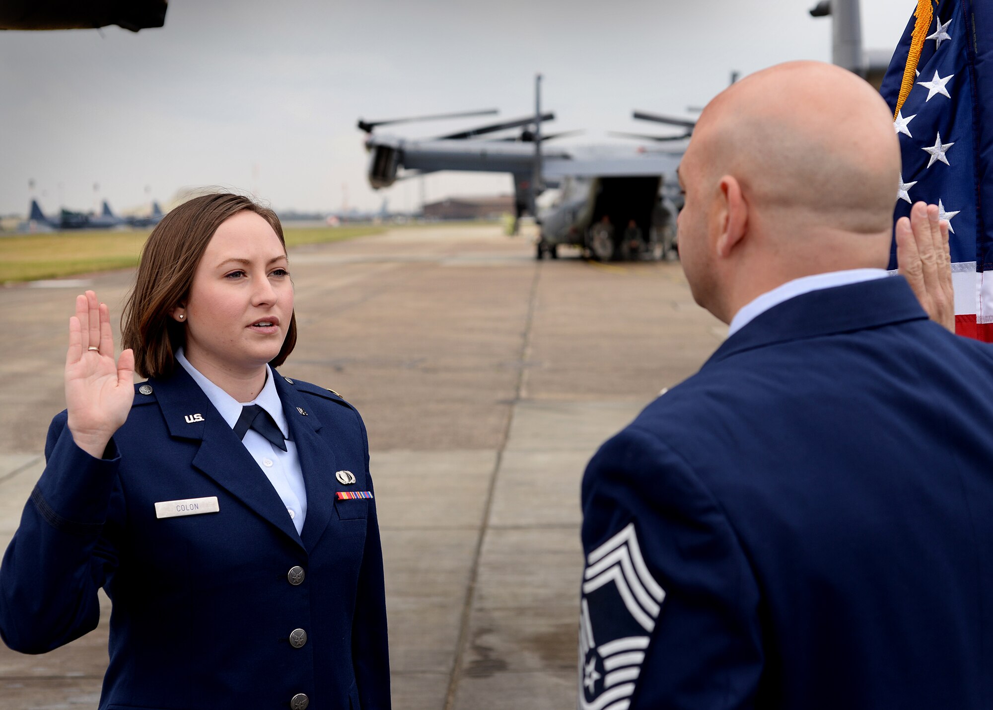 2nd Lt. Jenna Colón administers the oath of enlistment with her father, Chief Master Sgt. Jason Colón, 387th Air Expeditionary Group superintendent during his re-enlistment ceremony at Royal Air Force Mildenhall, England, March 21, 2016 Lt. Colón currently serves as a contracting specialist for the 48th Fighter Wing Contracting squadron at RAF Lakenheath, where she provides responsive support to combat and humanitarian operations and training exercises worldwide. (U.S. Air Force photo/ Technical Sgt. Matthew Plew)
