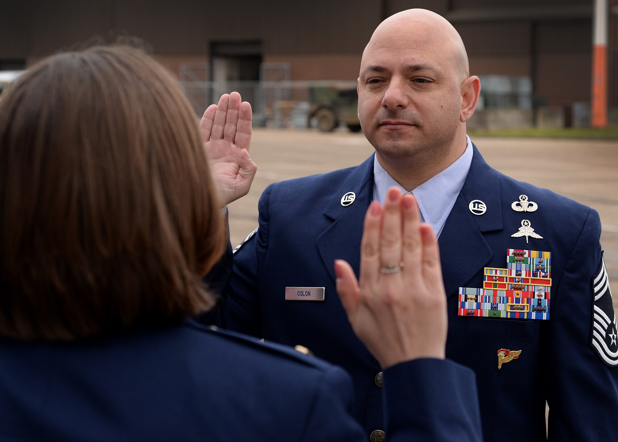 Chief Master Sgt. Jason Colón, recites the oath of enlistment with his daughter, 2nd Lt. Jenna Colón, 48th Contracting Squadron contracting specialist during his re-enlistment ceremony at Royal Air Force Mildenhall, England March 21, 2016. Chief Colón currently serves as the 387th Air Expeditionary Group superintendent at Abdullah Al Mubarak Air Base, Kuwait, where he serves as the principal enlisted advisor to the 387th AEG commander. (U.S. Air Force photo/ Technical Sgt. Matthew Plew)