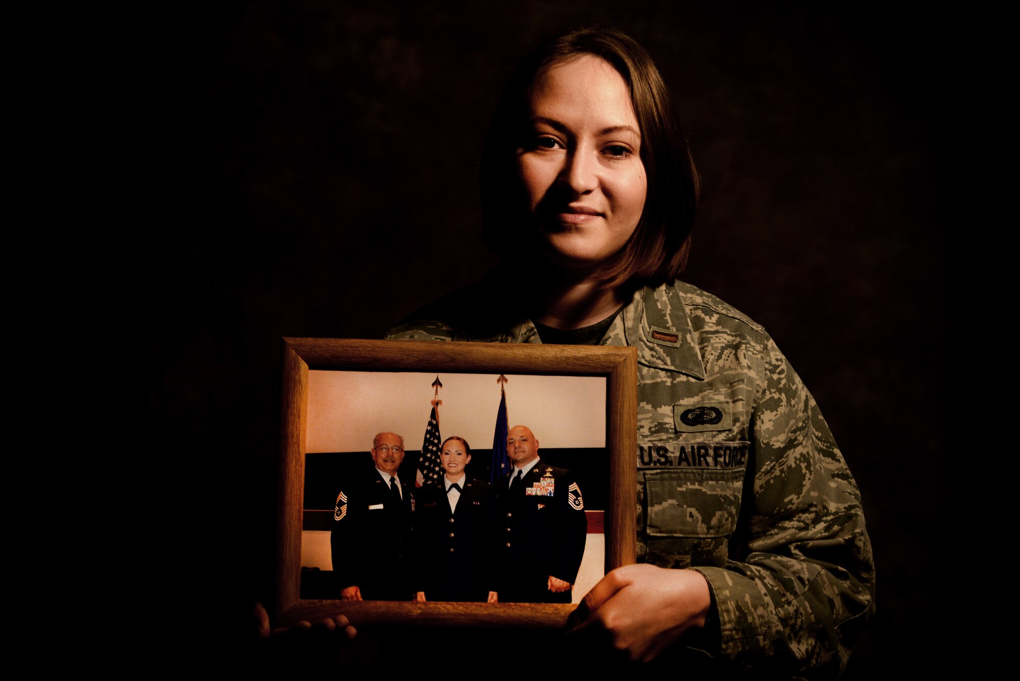 2nd Lt. Jenna Colón, 48th Contracting Squadron contracting specialist, holds a photo taken during her commissioning ceremony with her grandfather, Peter D. Colón (left), and her father, Jason (right), at Royal Air Force Lakenheath, England, March 18, 2016. Jenna is a fifth generation service member of the Colón family, whose military service dates back to World War I. (U.S. Air Force photo/ Technical Sgt. Matthew Plew)