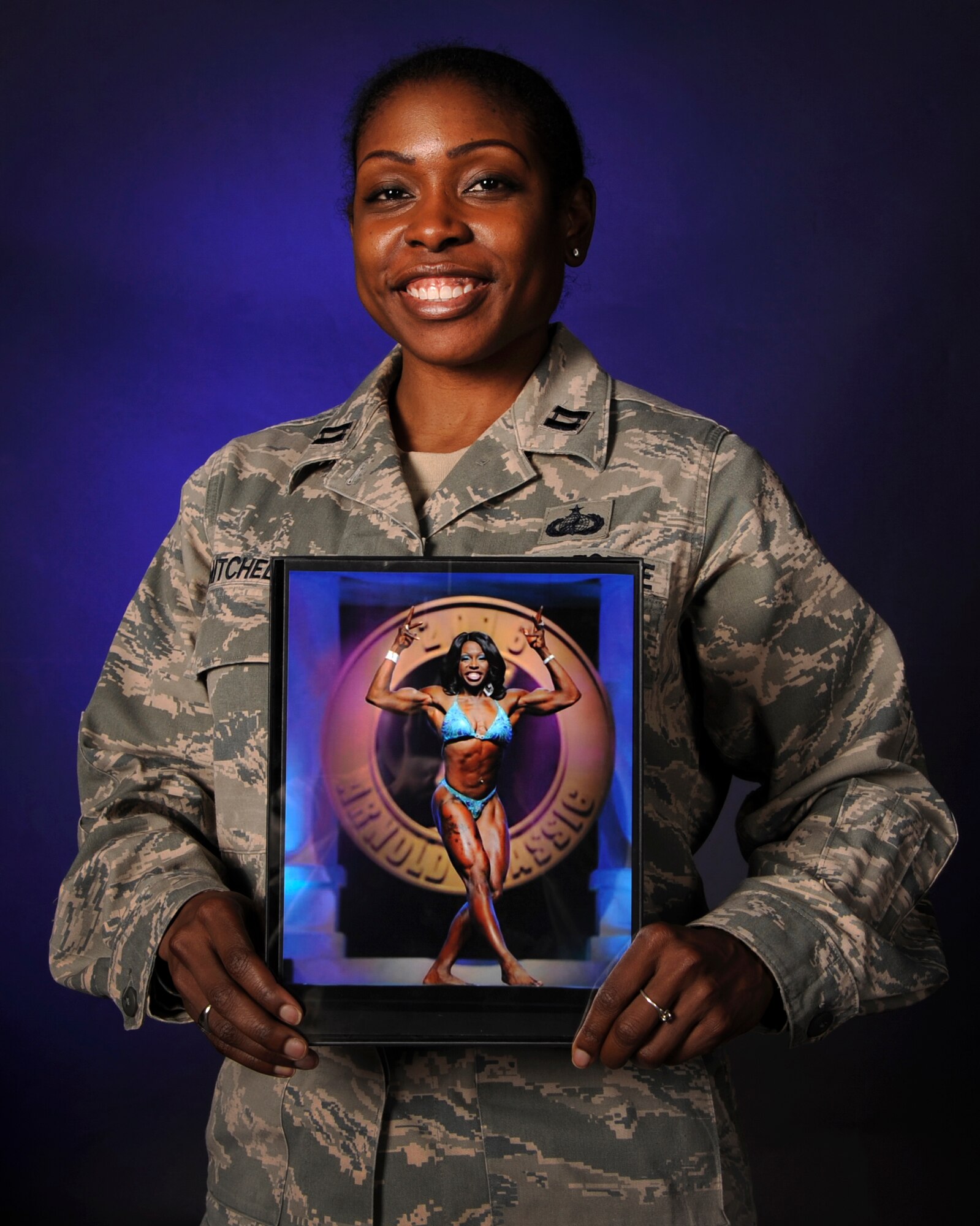 U.S. Air Force Capt. Tarah Mitchell, the 19th Comptroller Squadron financial analysis flight commander, proudly displays a photo of herself onstage at the 2016 Arnold Classic Women’s Physique competition. Mitchell placed eighth in the prestigious event. (U.S. Air Force photo/Senior Airman Harry Brexel) 
