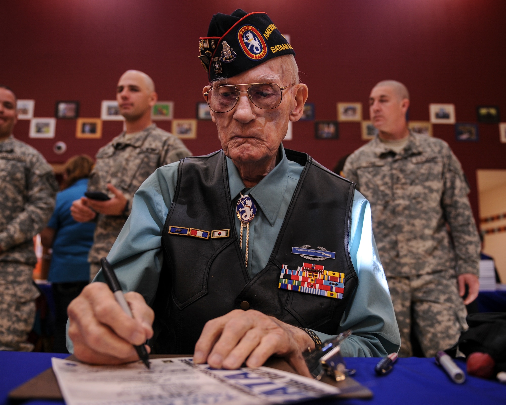 Retired U.S. Air Force Master Sgt. William Lyle Eldridge, Bataan Death March survivor, signs a runner’s certificate prior to the start of the 2016 Bataan Memorial Death March at White Sands Missile Range, N.M., March 18, 2016. The 26.2-mile march is designed to show participants what the prisoners of war at Bataan endured. In reality, however, the POWs marched more than 60 miles without food or water, while many were beaten and some never made it to the end. (U.S. Air Force photo by Senior Airman Harry Brexel)