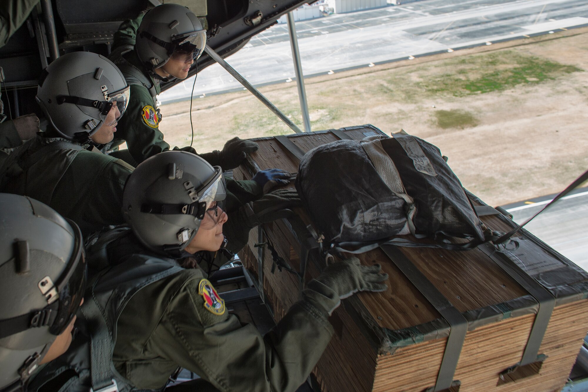 Loadmasters from the U.S. Air Force and Japan Air Self-Defense Force execute a low-cost , low-altitude drop over Yokota Air Base, Japan, March 23, 2016, during Non-Commission Officer Exchange program. JASDF loadmasters had an opportunity to deploy a LCLA bundle during a training mission. (U.S. Air Force photo by Osakabe Yasuo/Released) 