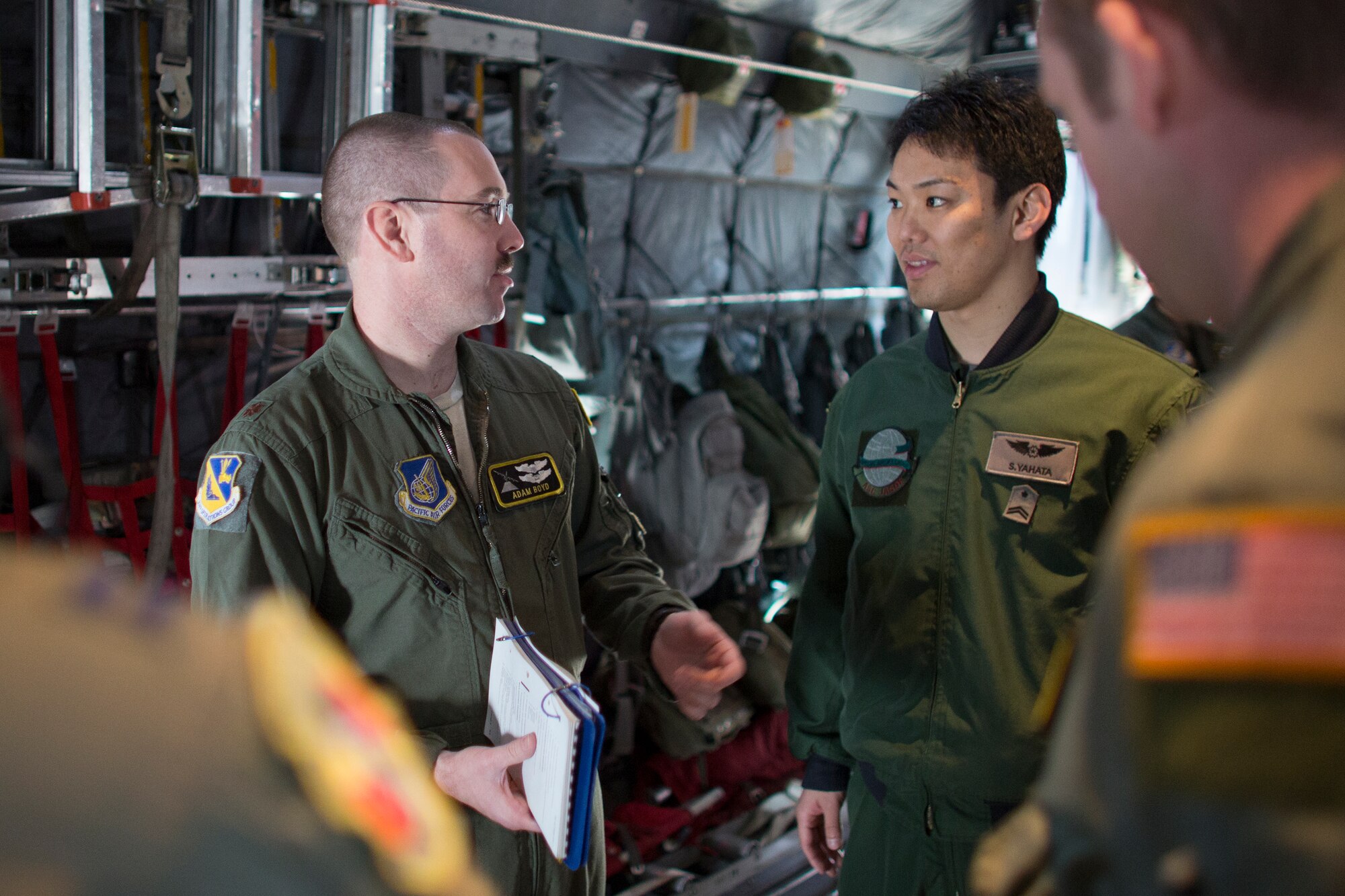 (Left to right) U.S. Air Force Maj. Adam Boyd, 374th Operations Group C-130 pilot and chief of group plans and program, talks to Japan Air Self-Defense Force Tech. Sgt. Suguru Yahata, Special Airlift Group B747 loadmaster, after a pre-flight briefing at Yokota Air Base, Japan, March 23, 2016. Yahata had his first opportunity to fly USAF C-130 Hercules during  non-commission officer exchange program. (U.S. Air Force photo by Osakabe Yasuo/Released) 