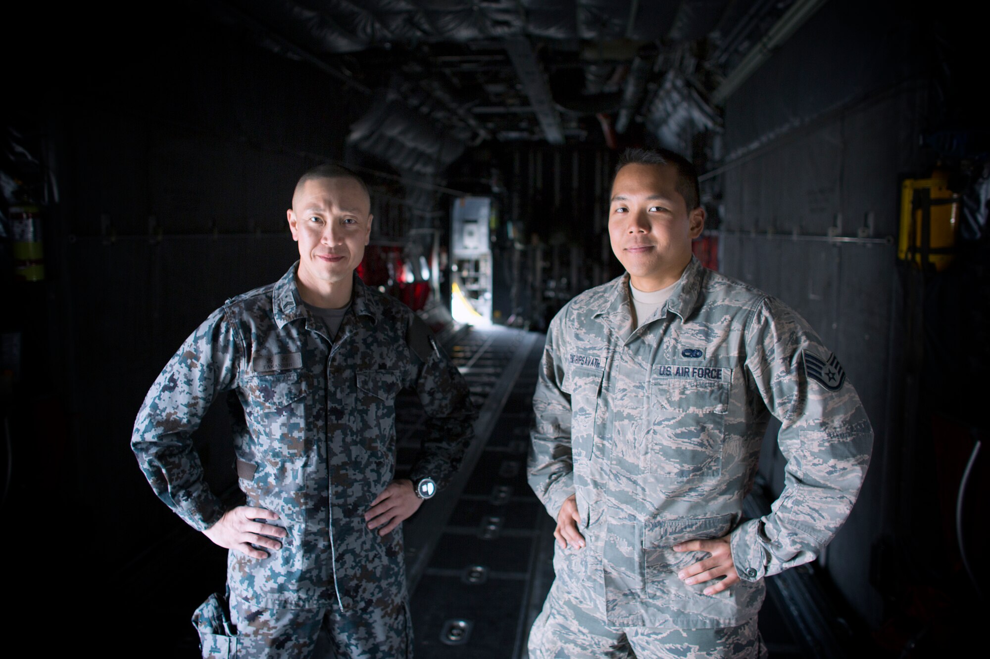 (Left to right) Japan Air Self-Defense Force Tech. Sgt. Masahiro Takanishi, Special Airlift Group crew chief, and U.S. Air Force Staff Sgt. Gene Phonthipsavath, 374th Aircraft Maintenance Squadron crew chief, pose for a photo inside of a C-130H Hercules at Yokota Air Base, Japan, March 23, 2016.  Yokota hosted sixteen JASDF NCO members in various work-places for nine days. (U.S. Air Force photo by Osakabe Yasuo/Released)