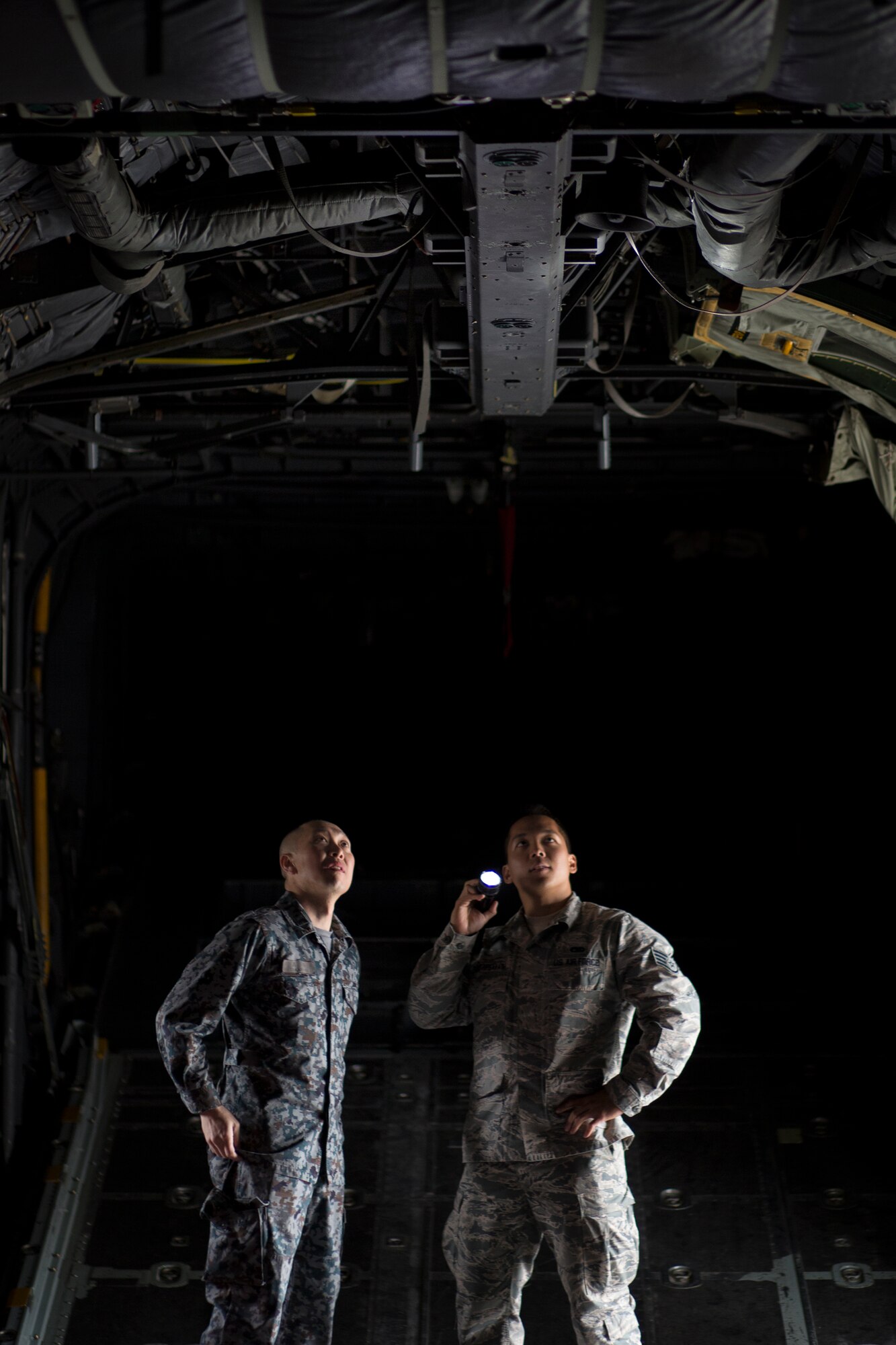 (Right to left) U.S. Air Force Staff Sgt. Gene Phonthipsavath, 374th Aircraft Maintenance Squadron crew chief, explains capabilities of C-130 equipment to Japan Air Self-Defense Force Tech. Sgt. Masahiro Nakanishi, Special Airlift Group crew chief, at Yokota Air Base, Japan, March 23, 2016. Yokota hosted sixteen JASDF NCO members in various work-places for nine days. (U.S. Air Force photo by Osakabe Yasuo/Released)