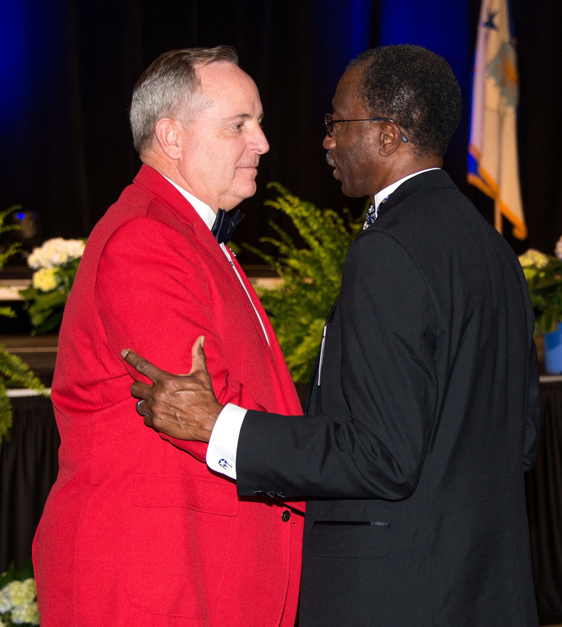 Chief of Staff of the Air Force Gen. Mark A. Welsh III Speaks with retired Brig. Gen. Leon Johnson after Welsh was inducted as an honorary Tuskegee Airman during the Tuskegee Airmen Foundation 75th Anniversary commemoration in Montgomery, Alabama, March 22, 2016. The red coat is part of the induction and represents the distinctive red tails of the Tuskegee Airmen fighter aircraft. Johnson is Board Chair Tuskegee Airman Foundation and National President, CEO and Board Chair Tuskegee Airmen, Inc. (US Air Force photo by Trey Ward)