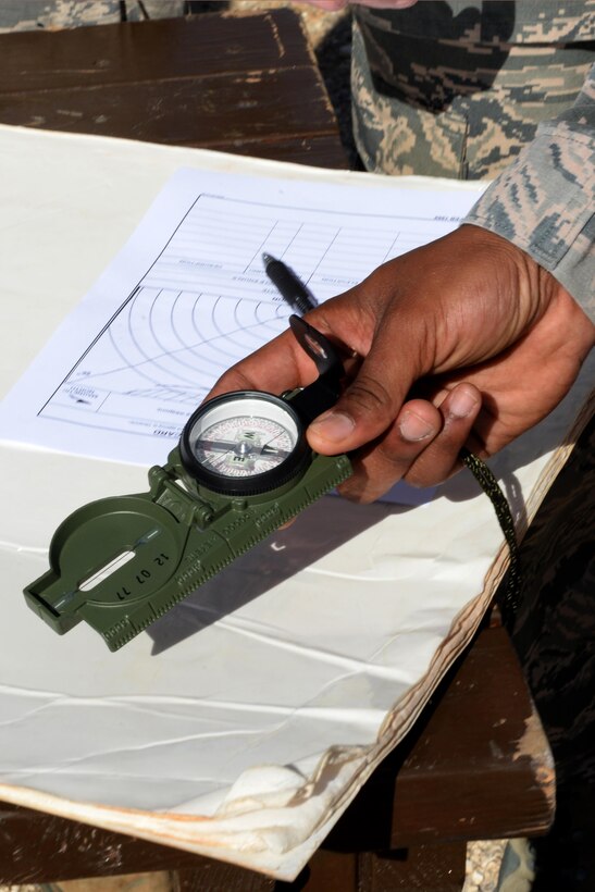 A 736th Security Forces Squadron commando warrior instructor demonstrates how to use a compass during a Prime Base Engineer Emergency Force exercise March 24, 2016, at Andersen Air Force Base, Guam. The Airmen developed their tactical skills to ensure CE personnel can meet impromptu contingency taskings and other unit-specific deployment requirements. (U.S. Air Force Photo/Airman 1st Class Alexa Ann Henderson)