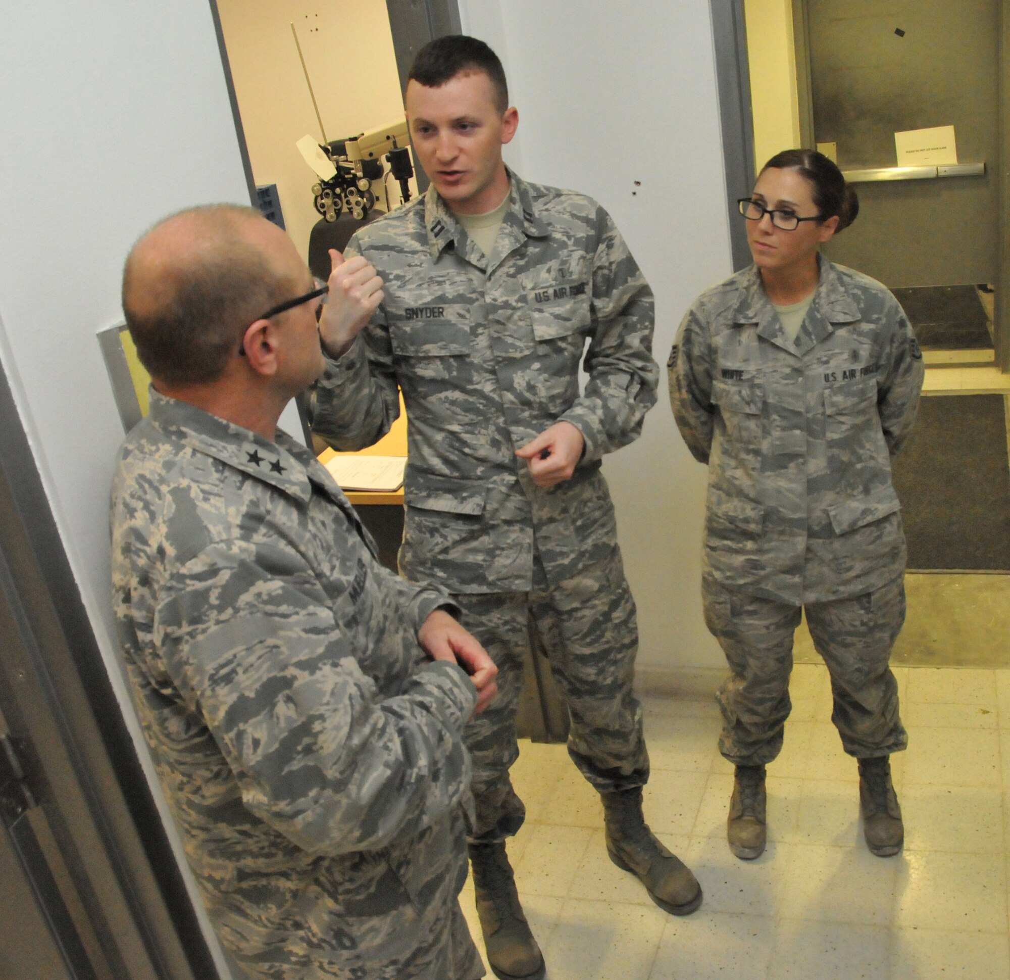 Capt. Benjamin Snyder (middle) and Staff Sgt. Jennifer White (right), 379th Expeditionary Medical Operations Squadron optometrists, speak with Maj. Gen. Andrew Mueller (left), Air Force Chief of Safety, about the laser exposure program March 16 at Al Udeid Air Base, Qatar. Snyder and White coordinate with flight medicine members as well as educate base personnel on laser exposure prevention and treatment procedures. (U.S. Air Force photo by Tech. Sgt. Terrica Y. Jones/Released)