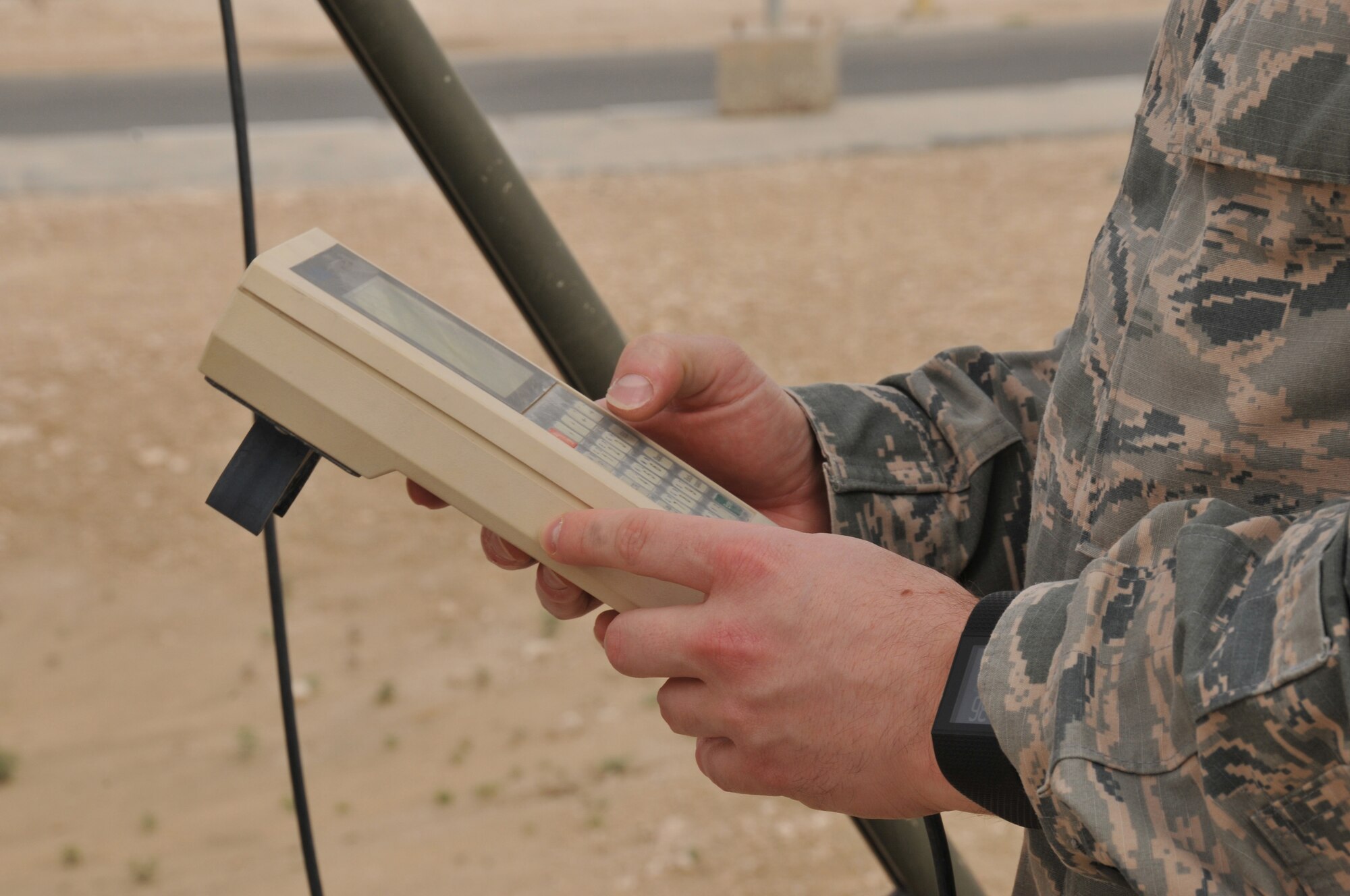 Capt. Matthew Perkins, 379th Expeditionary Operations Support Squadron weather flight commander, takes weather data from the Tactical Meteorological Observing System March 17 at Al Udeid Air Base, Qatar. Attached to the TMOS is a rain gauge, anemometer that reads wind speed and direction; a lightening sensor and a ceilometer, that tells how high the clouds are. (U.S. Air Force photo by Tech. Sgt. Terrica Y. Jones/Released)