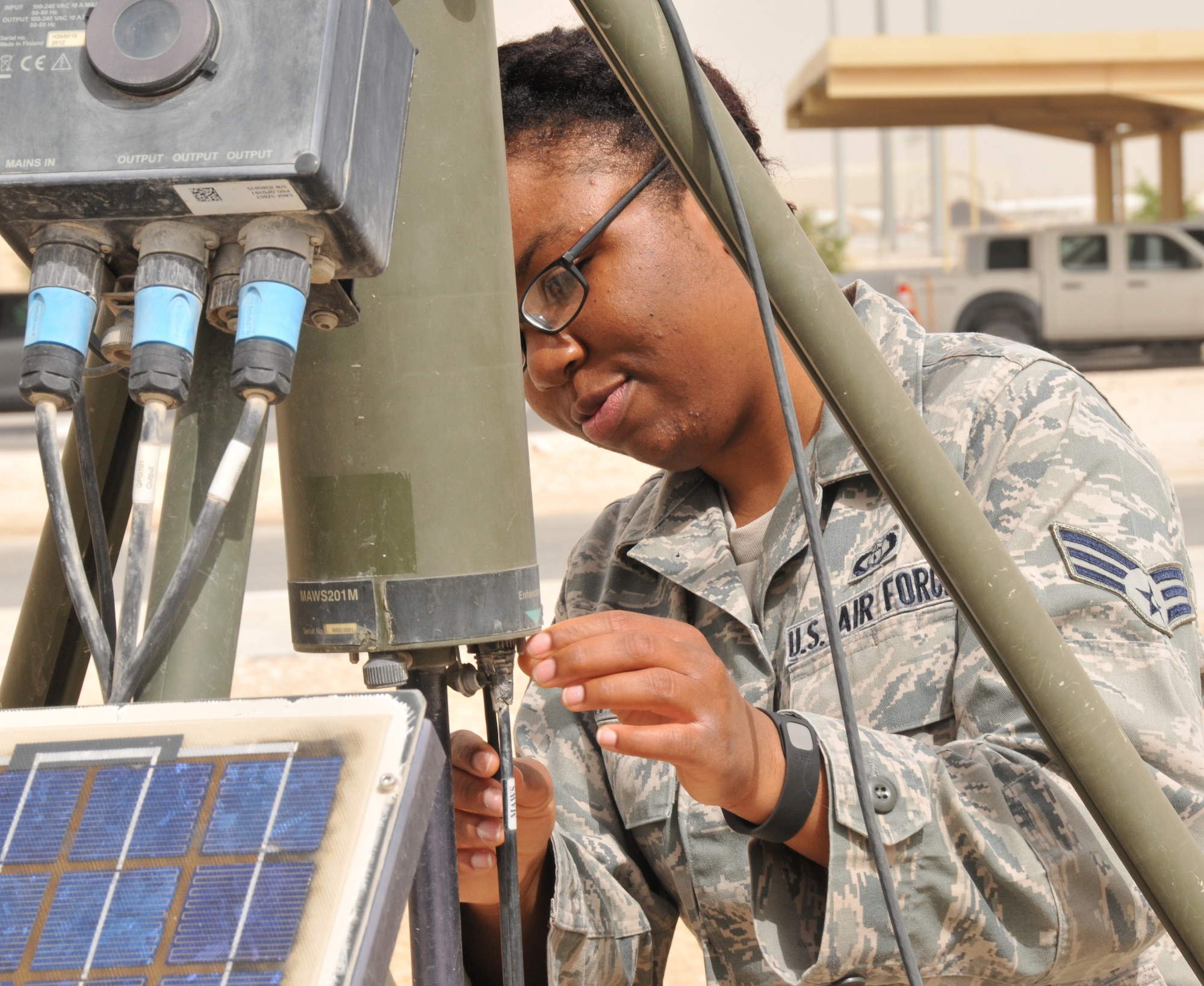 Senior Airman Tania Johnson-Hester, 379th Expeditionary Operations Support Squadron weather forecaster, deployed from Laughlin Air Force Base, Texas, checks the Tactical Meteorological Observing System connections March 17 at Al Udeid Air Base, Qatar. Johnson-Hester uses the TMOS to collect temperature, dew point, humidity and pressure data. (U.S. Air Force photo by Tech. Sgt. Terrica Y. Jones/Released)