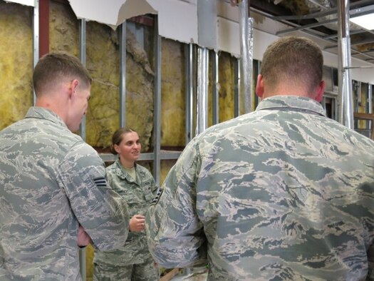 Former Bosnian refugee and 379th Expeditionary Civil Engineer Squadron operations engineering officer-in-charge, 1st Lt. Amela Kamencic, speaks with members of her team about on-going renovations throughout Al Udeid Air Base, Qatar March 16. (U.S. Air Force photo by Maj. Angela Webb/Released)