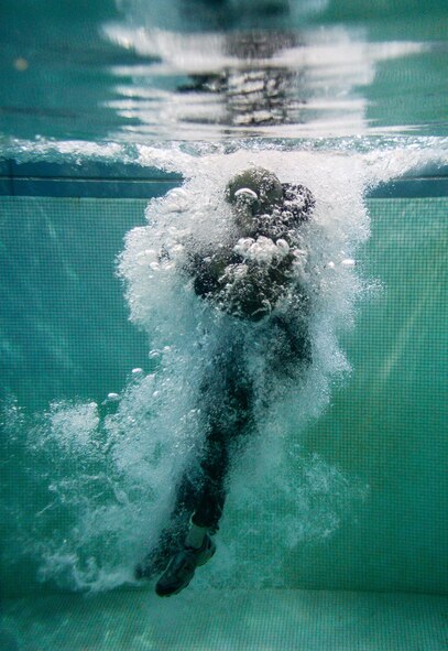 An Airman assigned to Barksdale Air Force Base, La., jumps into a pool during a Survival, Evasion, Resistance and Escape water survival class in Shreveport, La., March 15, 2016. The position reduces the chance of injury from any unseen obstacles underwater. (U.S. Air Force photo/Senior Airman Mozer O. Da Cunha)