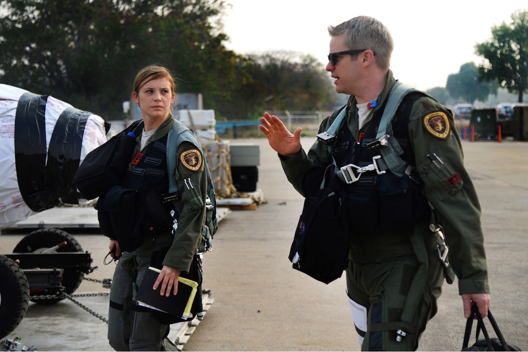 Air Force 1st Lt. Brittany Trimble receives last minute instructions from her flight lead, Air Force Maj. Shawn Walsh, as they walk to their F-16 aircraft at Korat Royal Thai Air Force Base, Thailand, March 15, 2016. Air Force photo by Staff Sgt. Amber E. Jacobs