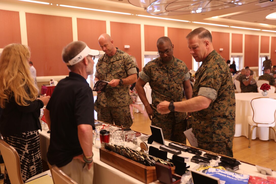 Col. Chandler Seagraves, right, Headquarters and Support Battalion commanding officer, Sgt. Maj. Veney Cochran, middle, Headquarters and Support Battalion sergeant major and Lt. Col. Giles Walger, Headquarters and Support Battalion executive officer look at sample memorabilia available at the Marine Corps Ball Expo at Marston Pavilion on Marine Corps Base Camp Lejeune March 15. Marine Corps Community Services hosted the expo to aid Marines plan their balls by linking vendors with members of unit ball committees.