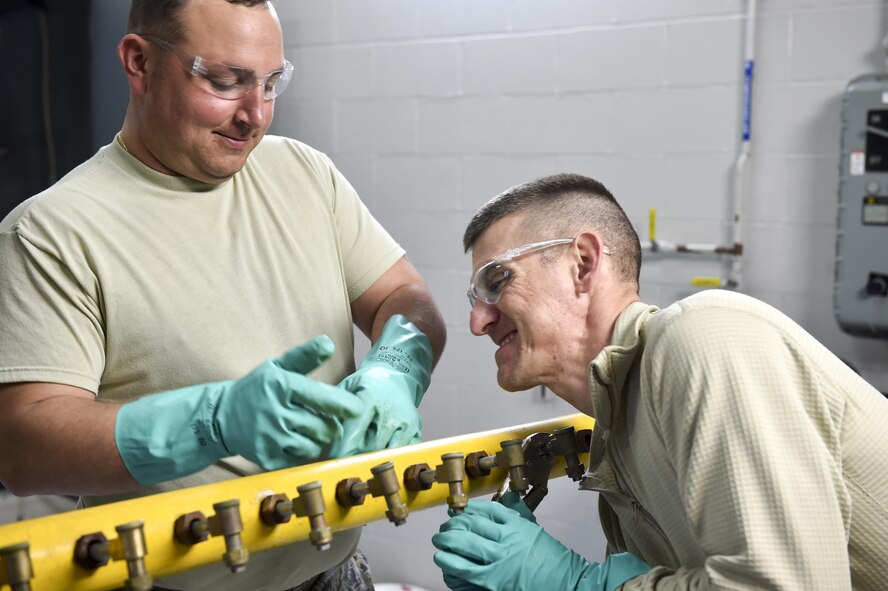 Tech. Sgt. Frank Serrao and Tech. Sgt. Thomas Neiswanger, aerial spray maintenance craftsmen with the 910th Maintenance Squadron, remove nozzles from an aerial spray boom for inspection and cleaning here, March 24. Aerial spray maintainers come from traditional aircraft maintenance jobs, learning a unique skillset through on-job training to maintain the equipment for the Department of Defense’s only aerial spray mission. The aerial spray mission includes insect control, vegetation control on bombing ranges and oil spill neutralization.  (U.S. Air Force photo/Eric M. White)