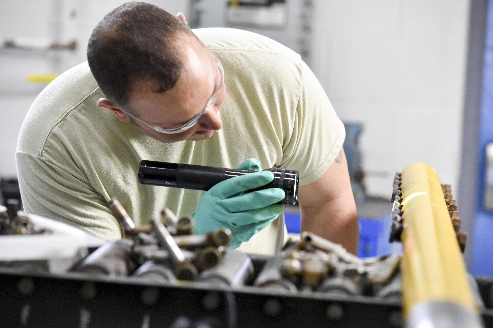 Tech. Sgt. Frank Serrao, an aerial spray maintenance craftsman with the 910th Maintenance Squadron, uses a flashlight to inspect the boom fittings for aerial spray nozzles here, March 24. Aerial spray maintainers come from traditional aircraft maintenance jobs, learning a unique skillset through on-job training to maintain the equipment for the Department of Defense’s only aerial spray mission. The aerial spray mission includes insect control, vegetation control on bombing ranges and oil spill neutralization.  (U.S. Air Force photo/Eric M. White)