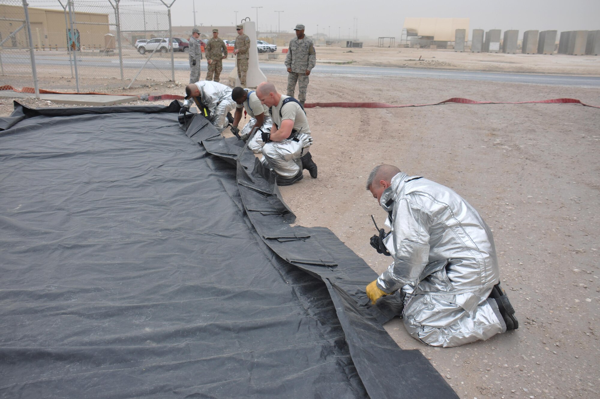 Firefighters assigned to the 379th Expeditionary Civil Engineer Squadron work to set up a decontamination processing area during a hazardous materials exercise at Al Udeid Air Base, Qatar March 16. The training exercise, which featured mock explosives and chemicals, provided first responders an opportunity to practice reacting to an emergency incident. Several emergency personnel participated in the exercise including explosive ordnance technicians, security forces and medics. (U.S. Air Force photo by Tech. Sgt. James Hodgman/Released)
