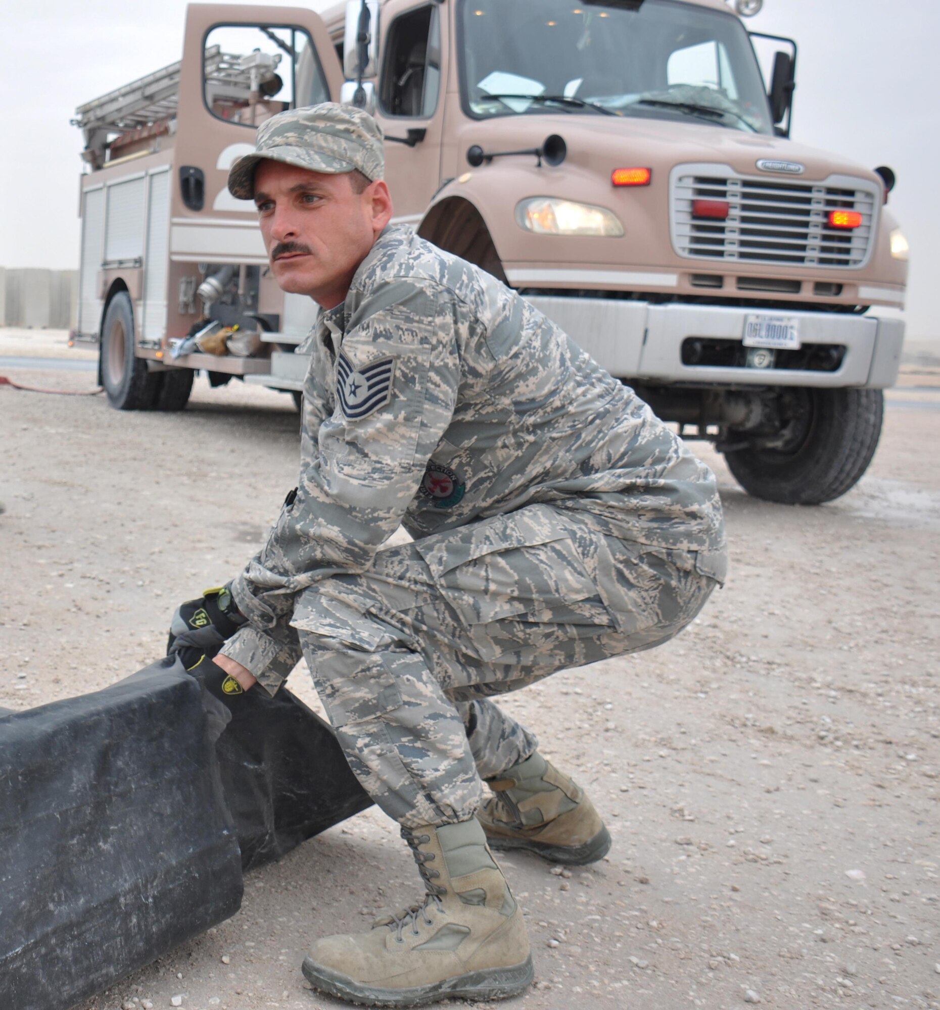 Tech. Sgt. Mickey Jackson, 379th Expeditionary Civil Engineer Squadron firefighter, helps set up a decontamination processing area outside the entrance of a hazardous materials exercise at Al Udeid Air Base, Qatar March 16. The training exercise, which featured mock explosives and chemicals, provided first responders an opportunity to practice reacting to an emergency incident. Several emergency personnel participated in the exercise including security forces and medics. (U.S. Air Force photo by Tech. Sgt. James Hodgman/Released)
